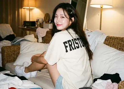 Girl Sitting on Woven Sofa with Back to Viewer